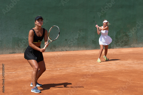 girls playing a tennis doubles match on a clay court © Beatriz