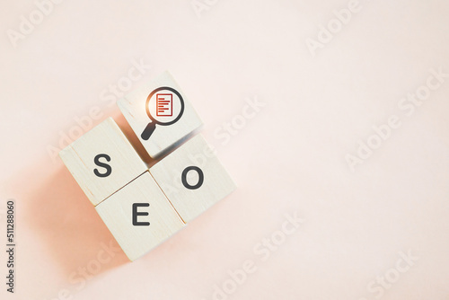 SEO, Search Engine Optimize, and magnifying glass with document inside sign on wooden cube blocks with sweet orange background included copy space