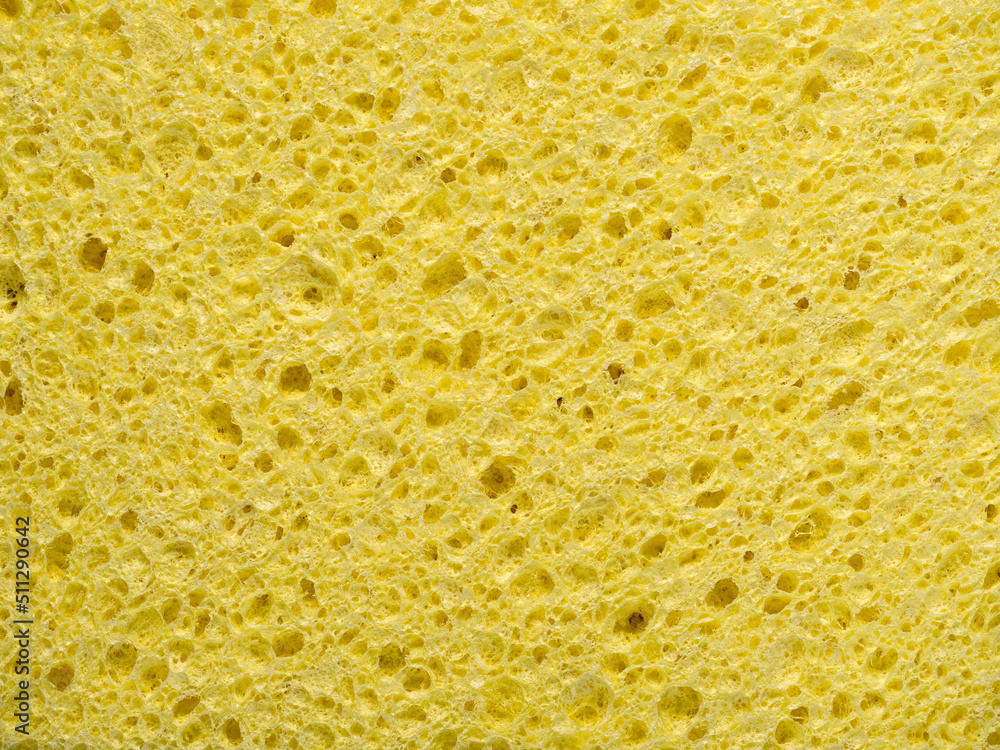 Abstract background with texture of yellow washing sponge in close-up Abstract background with texture of yellow washing sponge in close-up