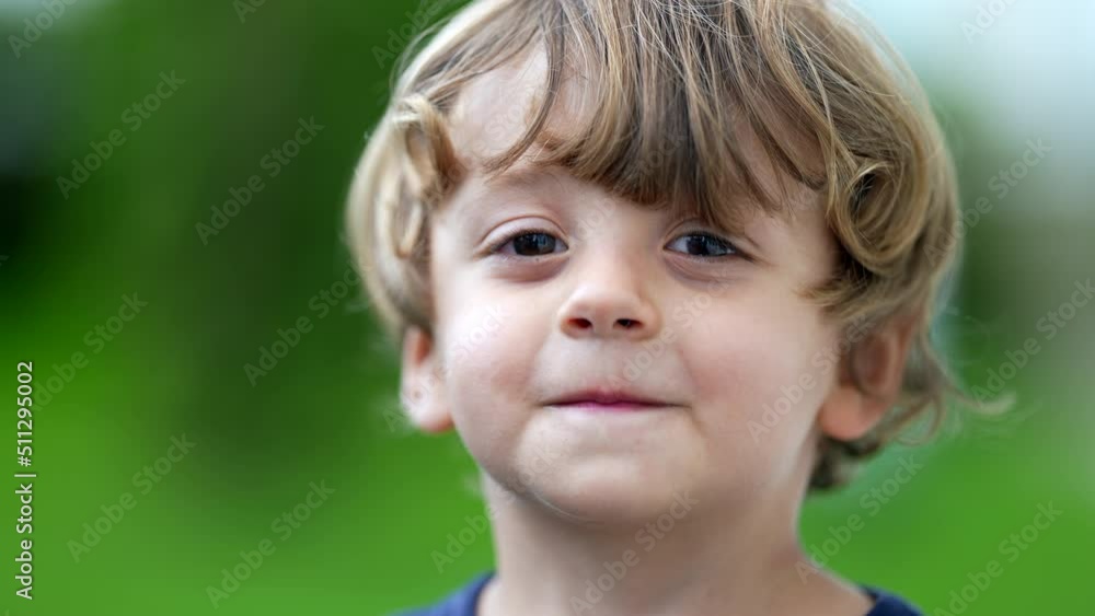 Adorable child portrait smiling at camera little boy face closeup smiles outside at park Adorable child portrait smiling at camera little boy face closeup smiles outside at park