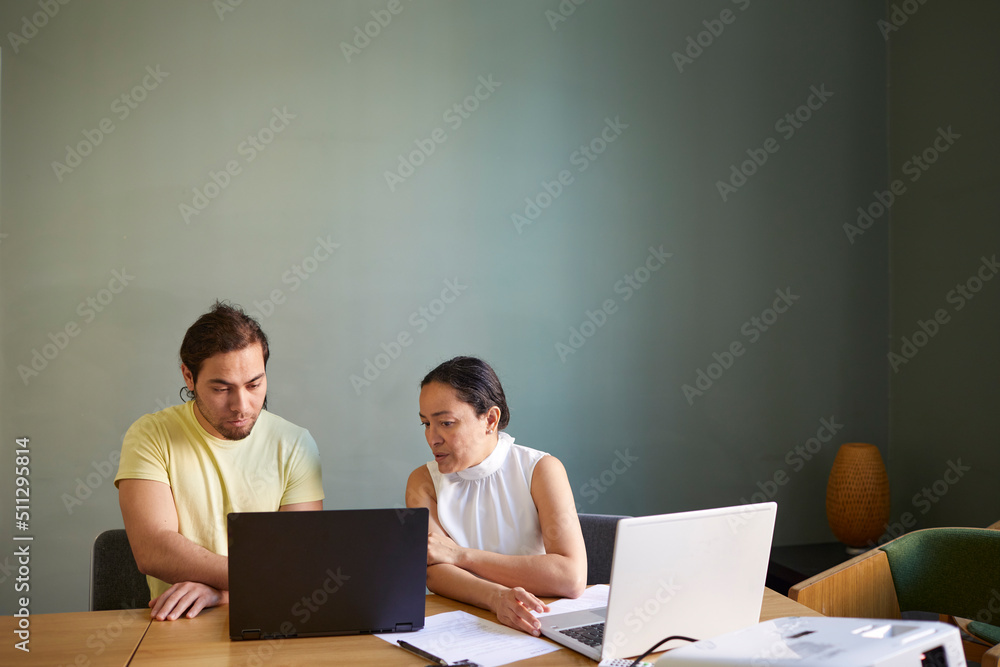 Coworkers in boardroom using laptop Coworkers in boardroom using laptop
