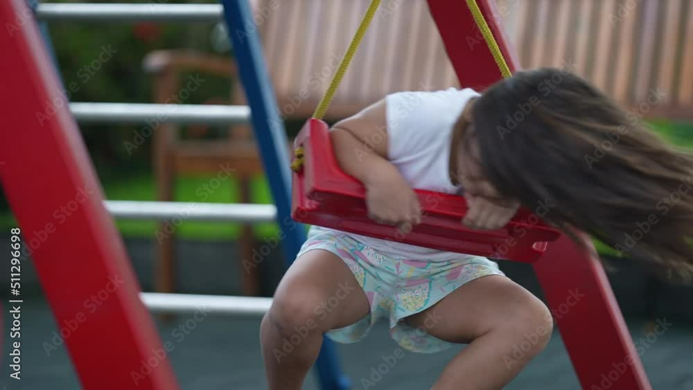 Child turning at playground swing one little girl twisting at park outdoors Child turning at playground swing one little girl twisting at park outdoors