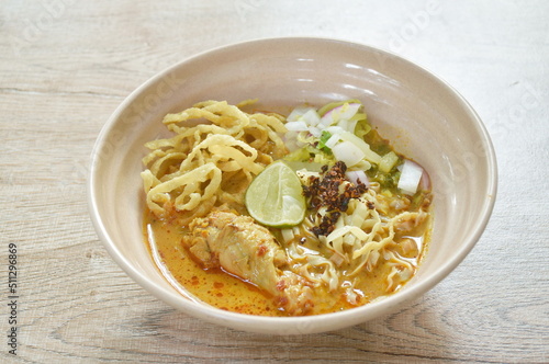 Thai northern style curry noodles in coconut milk soup with chicken on bowl