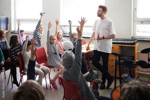 Children raising hands in class photo