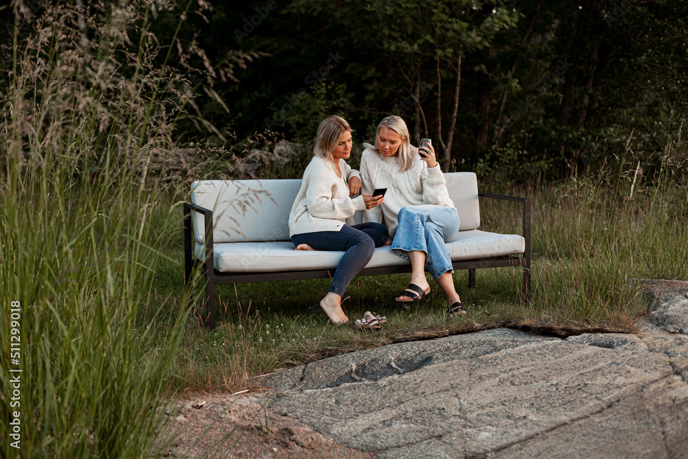 Female friends sitting on bench Female friends sitting on bench