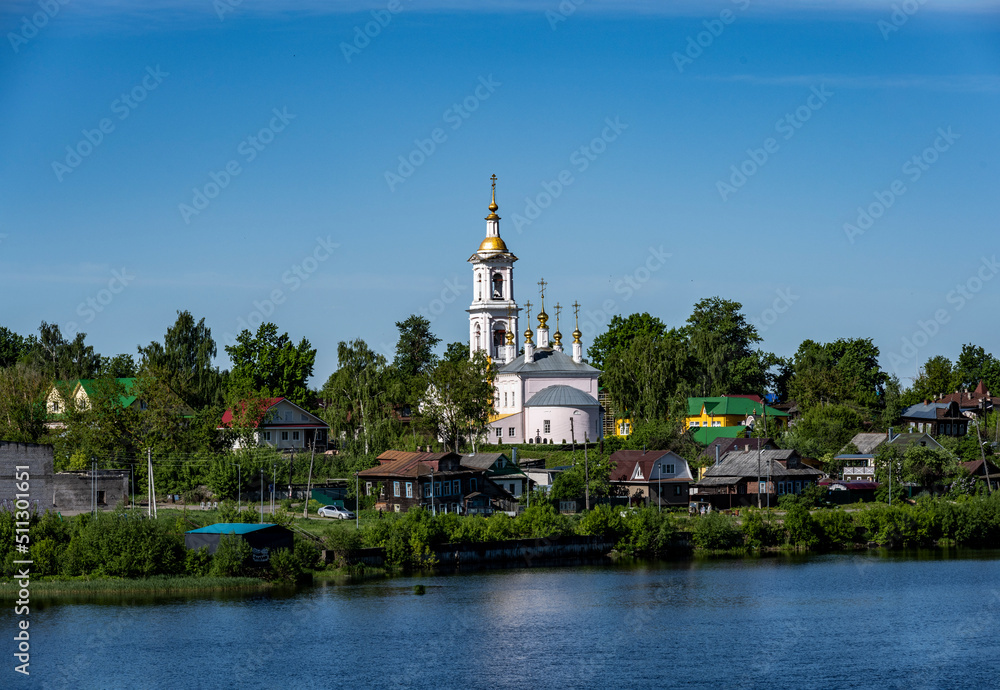 summer landscape with ancient churches against the backdrop of a forest and a river on a sunny day summer landscape with ancient churches against the backdrop of a forest and a river on a sunny day