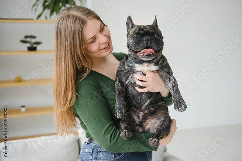 Young woman with her dog at home. Lovely pet