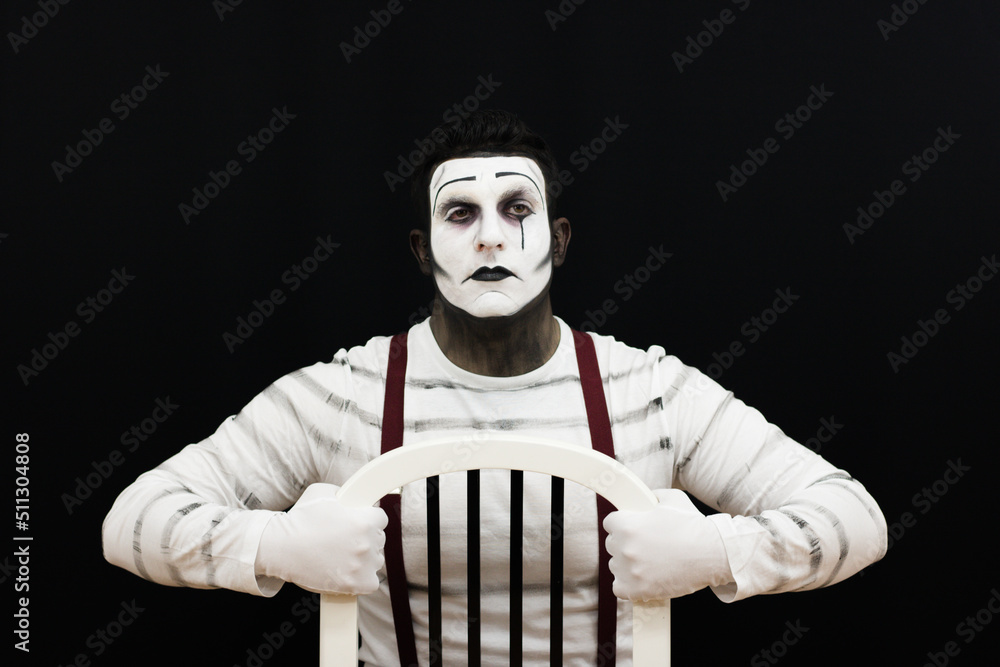 Fototapeta premium Retro male mime performing show with a chair, black and white