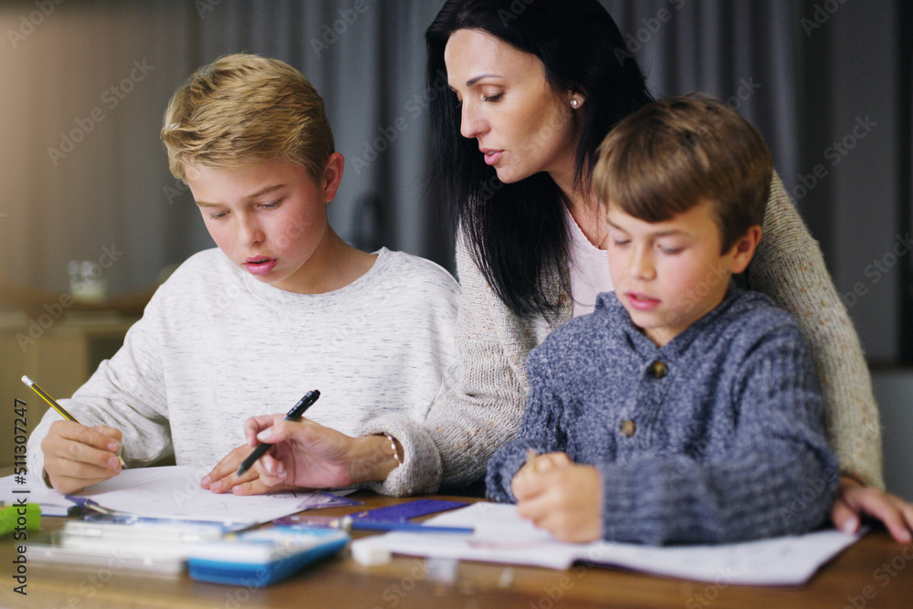 Education starts at home. Shot of a mother helping her sons with their homework. Education starts at home. Shot of a mother helping her sons with their homework.