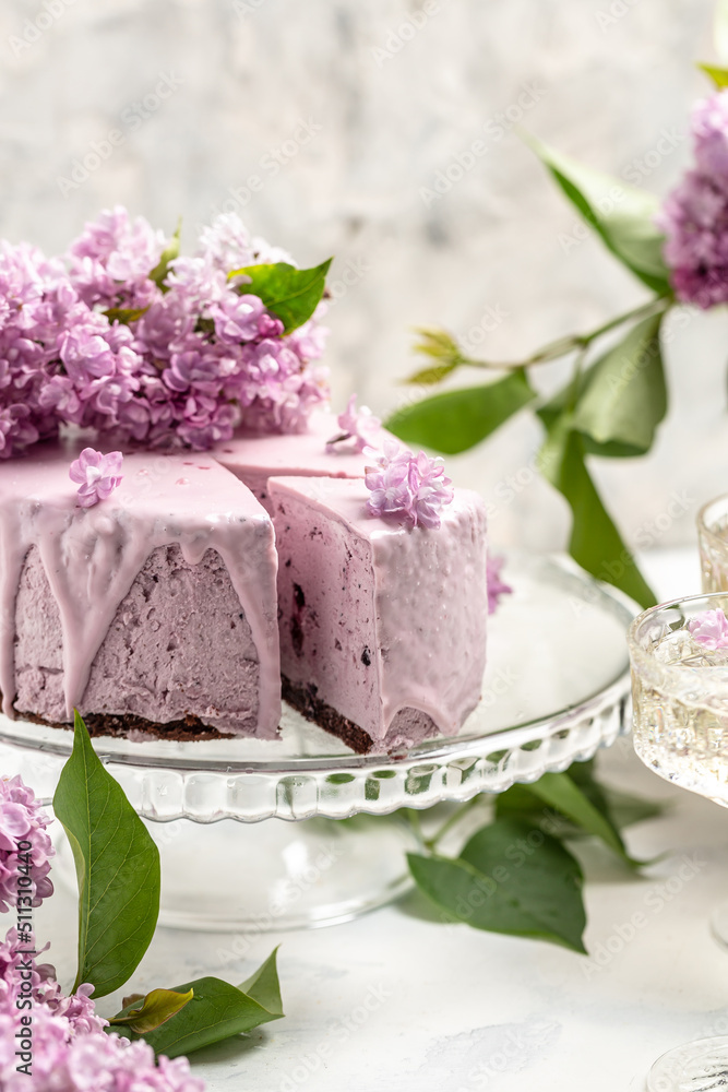 Delicious berry mousse cake, with prosecco, champagne, wine, bouquet of purple blooming lilacs, French cuisine, postcard, background Delicious berry mousse cake, with prosecco, champagne, wine, bouquet of purple blooming lilacs, French cuisine, postcard, background