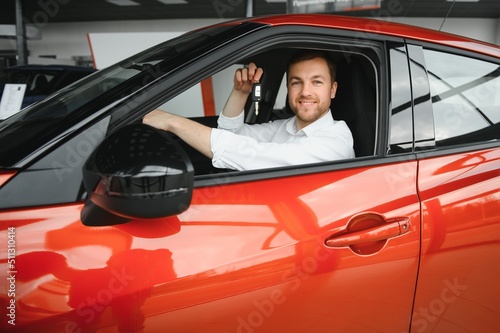 Man adult customer male buyer client chooses auto wants to buy new automobile touch check car in showroom vehicle salon dealership store motor show indoor. Sales concept