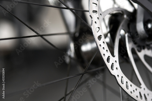 Bicycle disk brakes close up, metal disc attached to bike wheel, effective mountain bicycle brakes