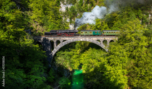 Billede på lærred Train driving over a stone bridge above the Vintgar gorge.