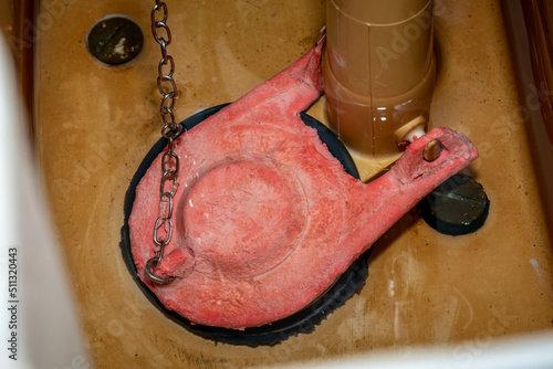 A rubber flapper valve in the toilet tank illustrating severe chlorine damage. photo