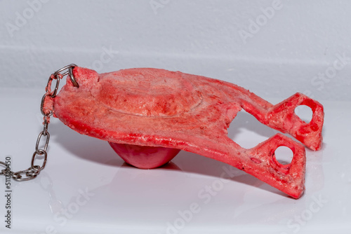Фотография Side view of a rubber flapper valve from a toilet tank illustrating severe chlorine damage