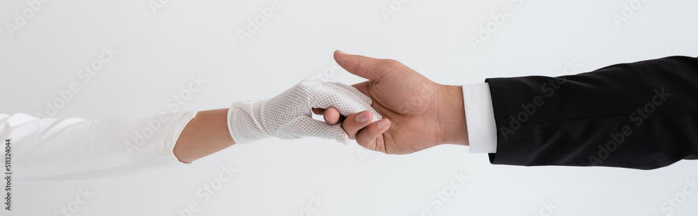 cropped view of groom and bride holding hands isolated on grey, banner. cropped view of groom and bride holding hands isolated on grey, banner.