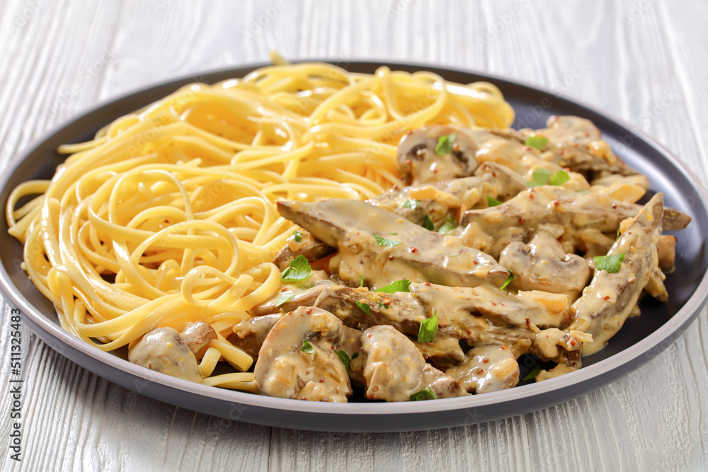 liver stroganoff with spaghetti on plate, top view liver stroganoff with spaghetti on plate, top view