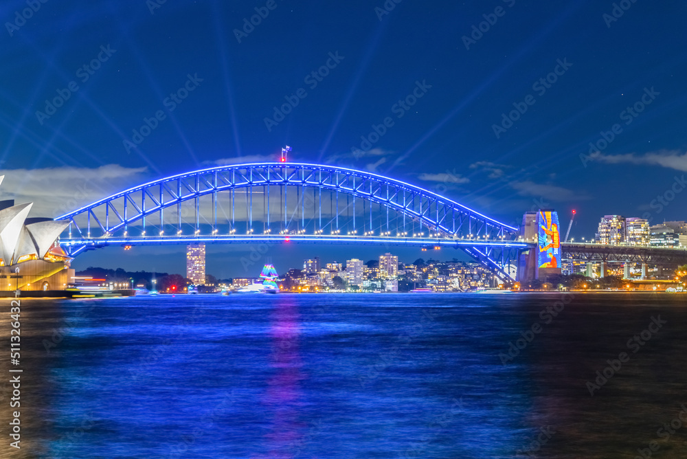 Naklejka premium Colourful Light show at night on Sydney Harbour NSW Australia. The bridge illuminated with lasers and neon coloured lights 
