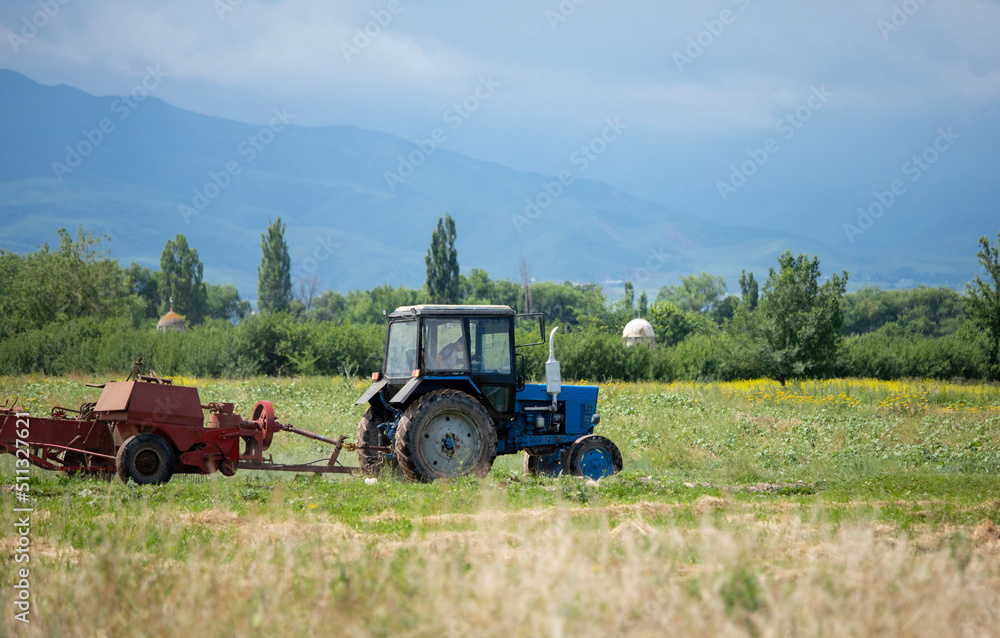 Fototapeta premium An old soviet tractor working in a field in Kyrgyzstan.