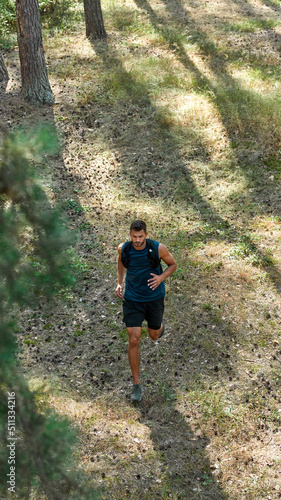 Top view of sportsman jogging in coniferous forest