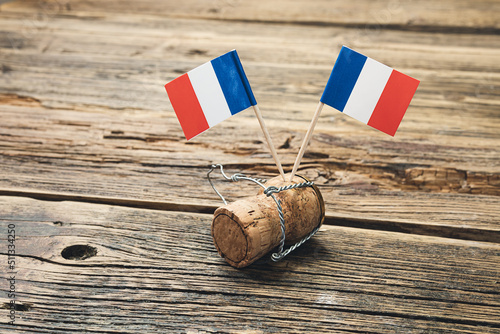 French flags on a french champagne bottle cork on an old wooden table, Bastille Day and French National Day 14 July concept