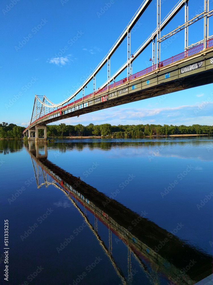 Naklejka premium Kyiv, Ukraine - May 24, 2022: Landscape of the pedestrian bridge in Kiev. Summer time