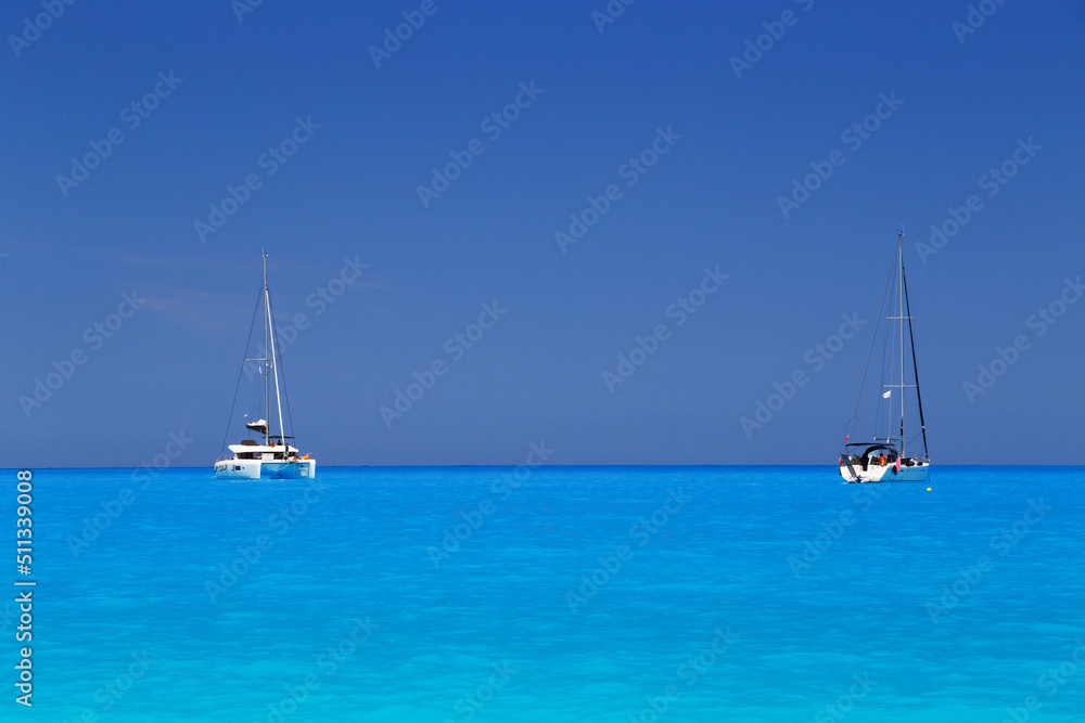White yachts anchored in fantastic Myrtos Beach turquoise and blue bay. Summer scenery of famous and extremely popular travel destination in Cephalonia island, Greece, Europe. White yachts anchored in fantastic Myrtos Beach turquoise and blue bay. Summer scenery of famous and extremely popular travel destination in Cephalonia island, Greece, Europe.
