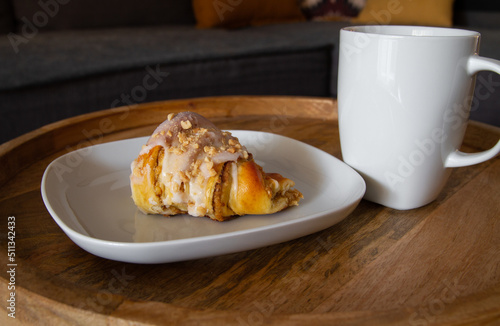 Fresh traditional polish pastry with poppy-seed filling and nuts. St. Martin's croissant. Rogal marciński or świętomarciński and white ceramic coffee cup or tea mug.