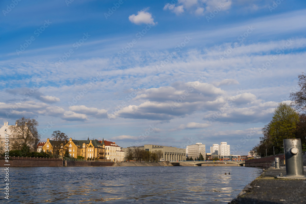 Fototapeta premium Buildings near river and sky at background in Wroclaw