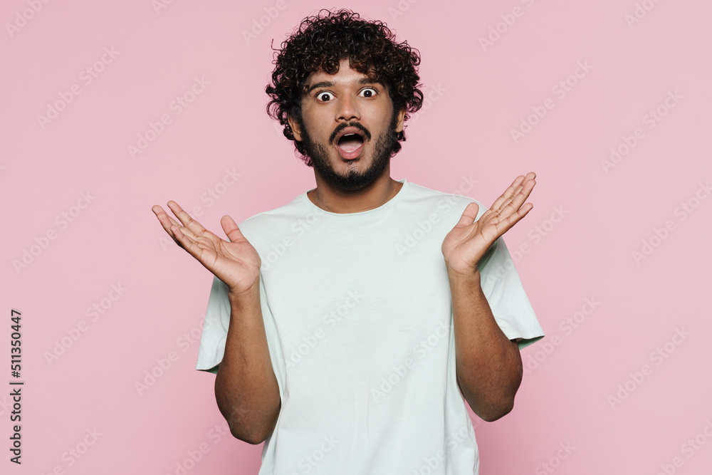 Young man with beard gesturing and expressing surprise at camera Young man with beard gesturing and expressing surprise at camera