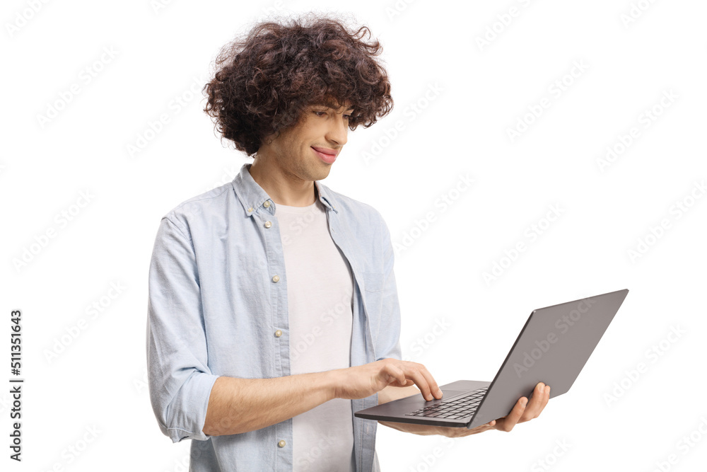 Guy with a curly hair standing and working on a laptop computer Guy with a curly hair standing and working on a laptop computer