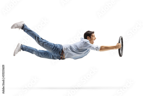 Fotografía Full length profile shot of an excited young man flying and holding a steering w
