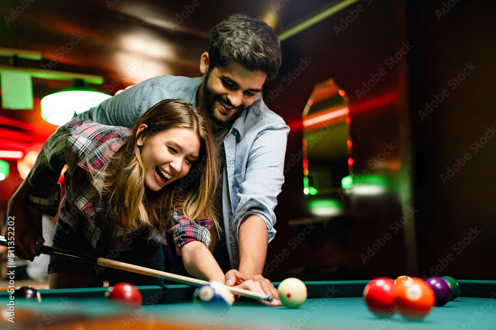 Portrait of young couple having fun playing billiard together. Photos |  Adobe Stock