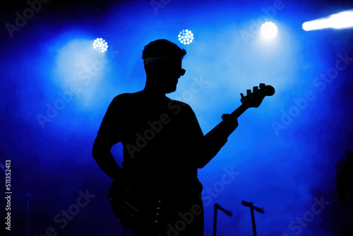 Bass player silhouette on stage.