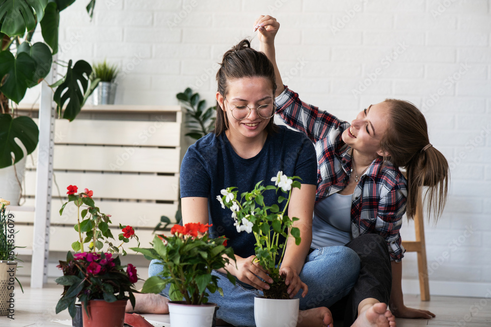 A lesbian couple planting flowers together for their home. A lesbian couple planting flowers together for their home.