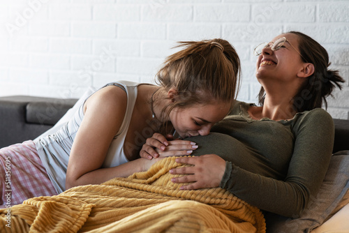 Pregnant  lesbian couple is excited about the arrival of their child.She was kissing her partner's belly. photo