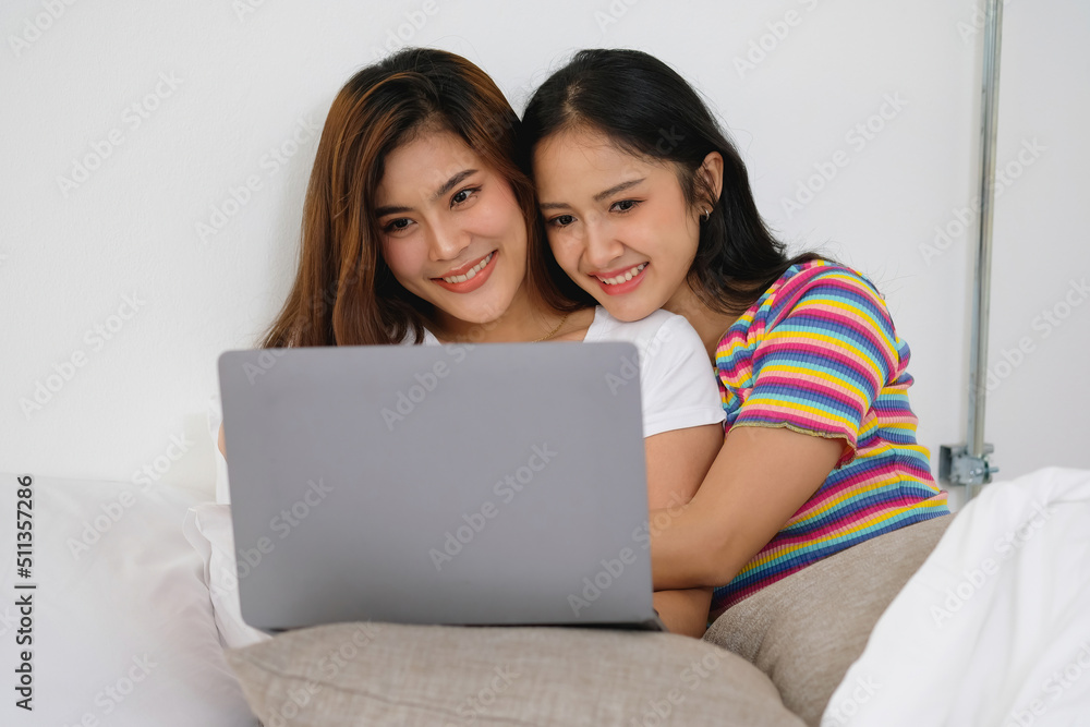 lgbtq lgbt concept homosexuality Two beautiful women happily express their love for each other playing laptop computers in their comfortable homes. lgbtq lgbt concept homosexuality Two beautiful women happily express their love for each other playing laptop computers in their comfortable homes.
