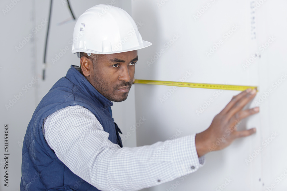 man measuring the wall with a measuring tape man measuring the wall with a measuring tape