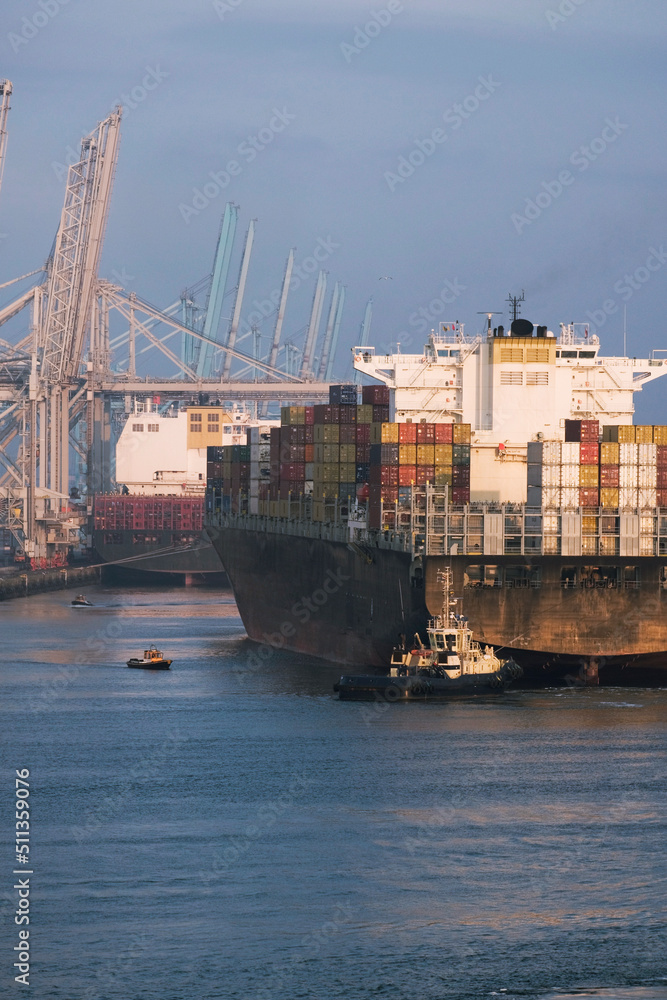 Rotterdam, Netherlands - 07 11 2021: Large container vessel leaving the port with tug assistance from the stern