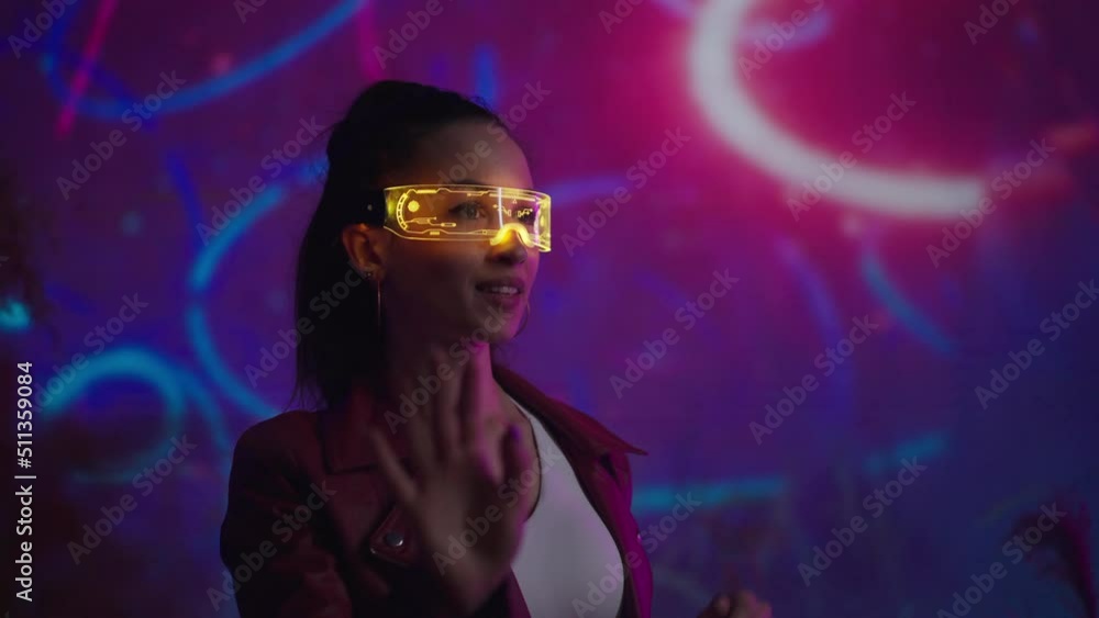 Futuristic young woman in VR environment with smart glasses. Concept of augmented reality game, futuristic lifestyle. Futuristic young woman in VR environment with smart glasses. Concept of augmented reality game, futuristic lifestyle.