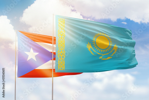 Sunny blue sky and flags of kazakhstan and puerto rico