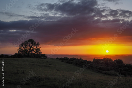 Stunning orange sunset looking out from Butser Hill, the highest point on the chalk ridge of the South Downs, Hampshire, UK