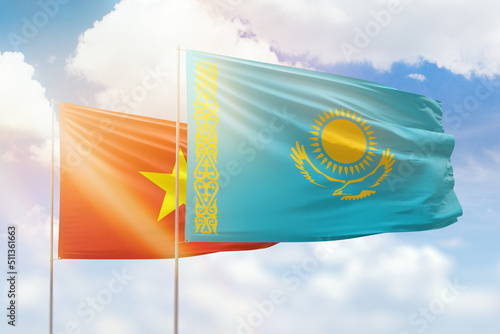Sunny blue sky and flags of kazakhstan and vietnam