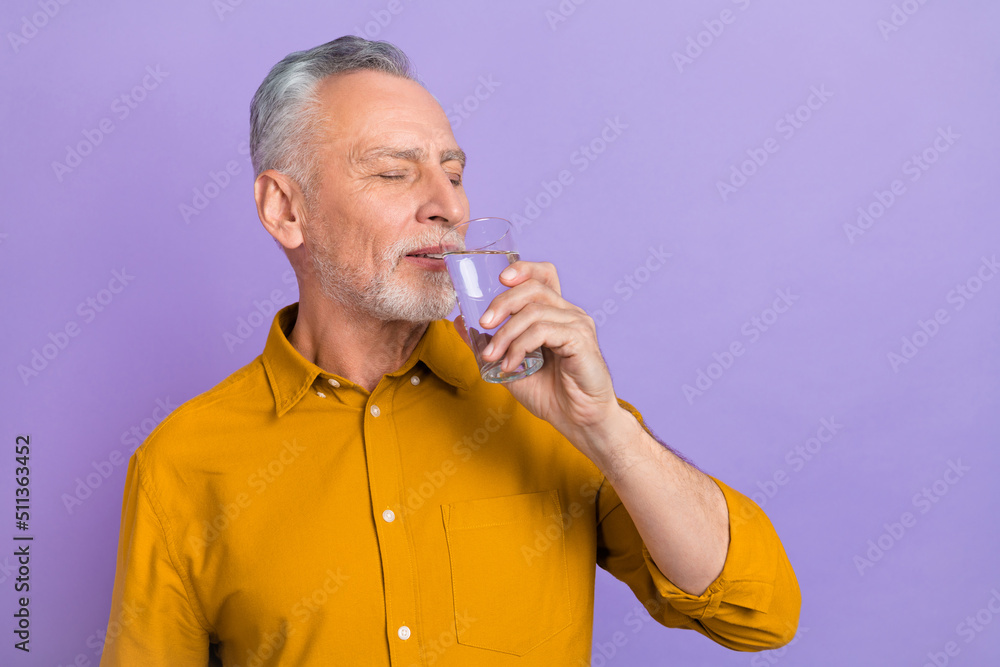 Photo of senior handsome man enjoy fresh water health care morning isolated over violet color background Photo of senior handsome man enjoy fresh water health care morning isolated over violet color background