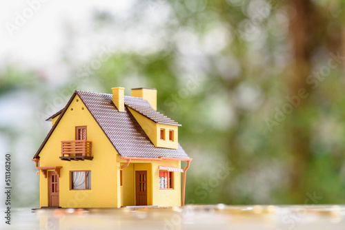 Mortgage loan or home equity loan, financial concept : Model residential house and coins or money on a table, depicting home loan or borrowing money to purchase a new home for first time homebuyer.