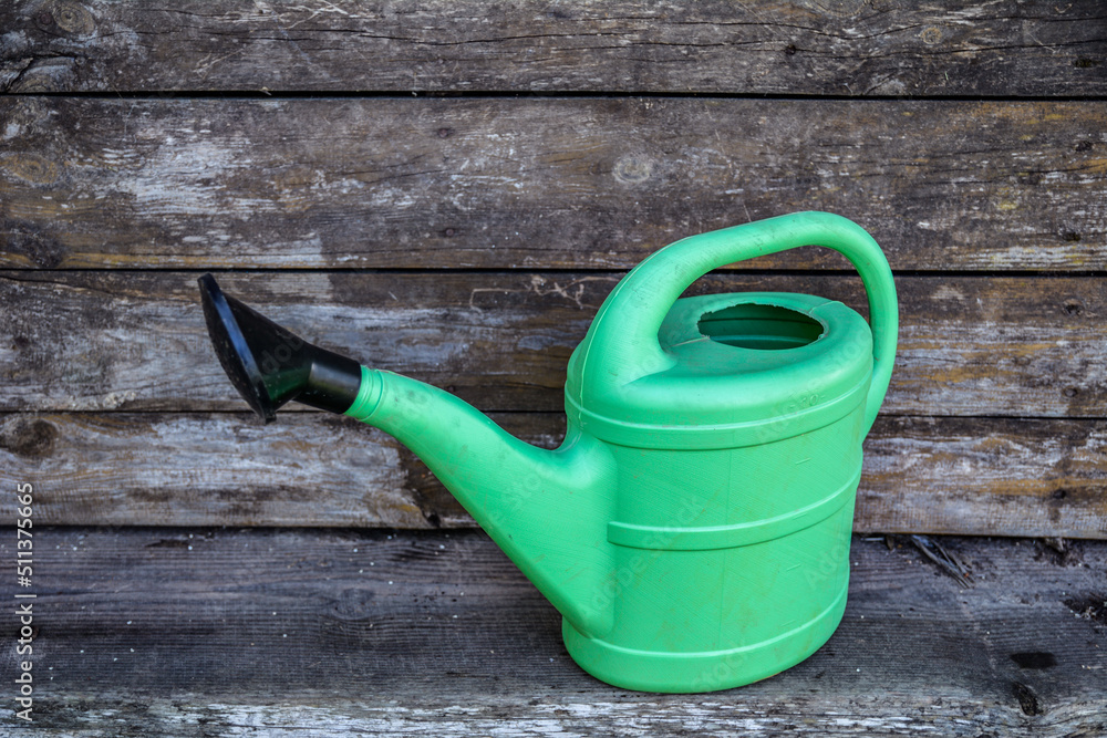 Green plastic sprinkling can outdoor in garden. Watering can. Green plastic sprinkling can outdoor in garden. Watering can.