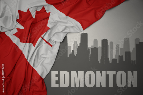 abstract silhouette of the city with text Edmonton near waving national flag of canada on a gray background.