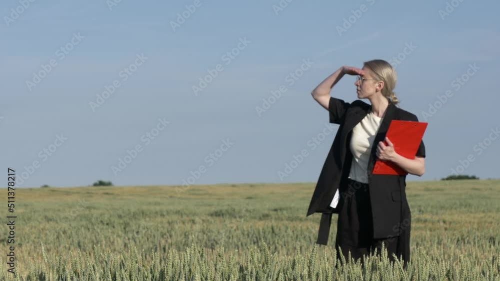 employee of an agricultural firm with notebook checks the quality of wheat in the field employee of an agricultural firm with notebook checks the quality of wheat in the field