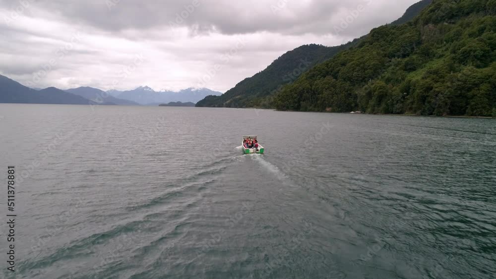 Tourists In Speed Boat Over Sea By Forest On Mountains During Vacation - Puerto Montt, Argentina Tourists In Speed Boat Over Sea By Forest On Mountains During Vacation - Puerto Montt, Argentina