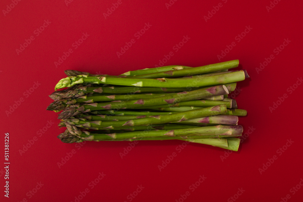 A bunch of asparagus on a red background. A bunch of asparagus on a red background.